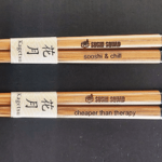 A set of wooden chopsticks with chinese writing on them.