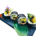 Four sushi rolls on a black plate.