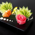 Japanese sashimi plate with cucumbers and a rose.