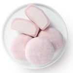 A white plate with pink and white cookies on it.